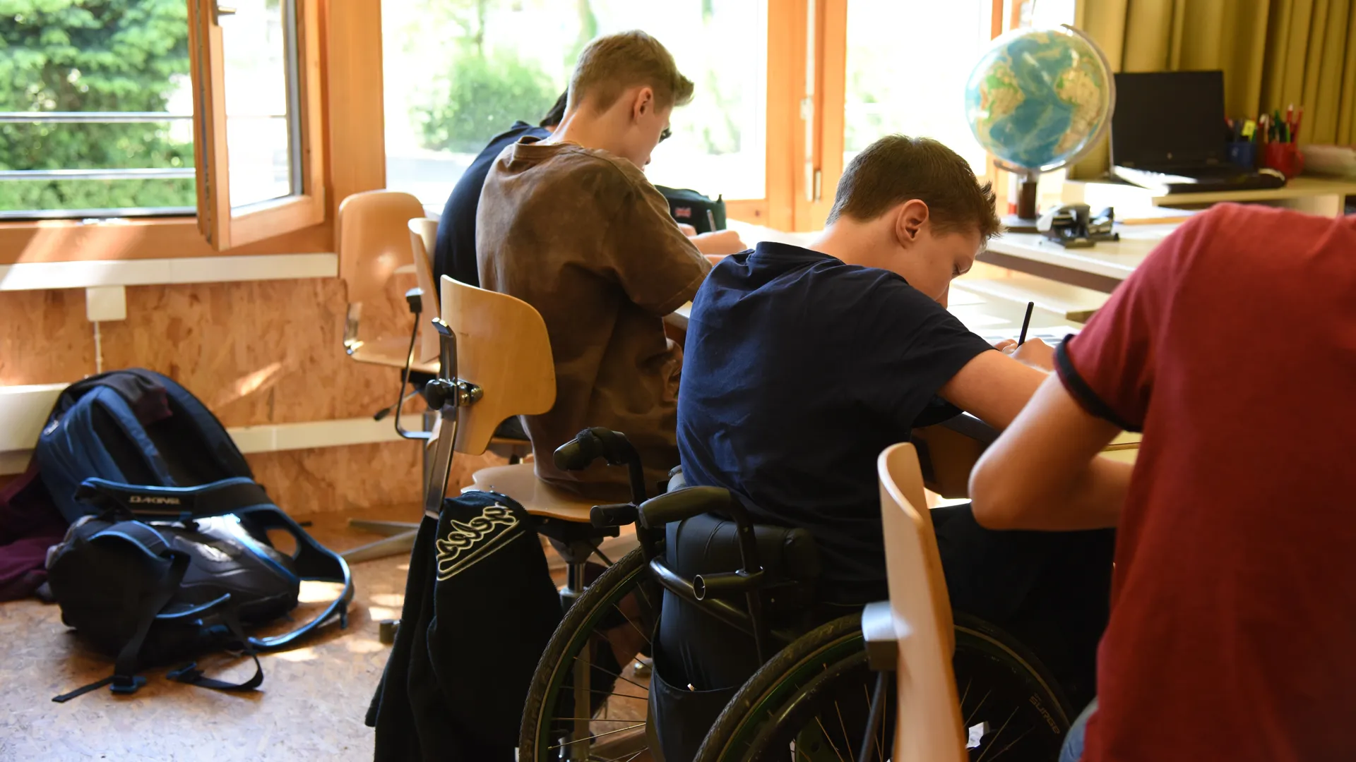 Junger Rollstuhlfahrer in der Schule